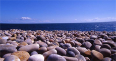 Pebbles and sea and sky and clouds